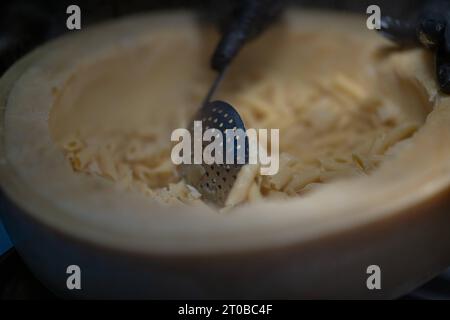 Pasta aus einem Parmesanlaib, Food, Deutschland, Rhénanie-Palatinat, 02.10.2023, das Bild zeigt eine Küchenszene, die eine kulinarische Tätigkeit darstellt. Der zentrale Fokus liegt auf einem Parmesanlaib mit Pasta, die mit einem Metalllöffel umgerührt wird. *** Pâtes à partir d'un pain de parmesan, alimentation, Allemagne, Rhénanie-Palatinat, 02 10 2023, l'image montre une scène de cuisine représentant une activité culinaire. l'accent est mis sur une miche de parmesan avec des pâtes agitées avec une cuillère en métal Credit : Imago/Alamy Live News Banque D'Images