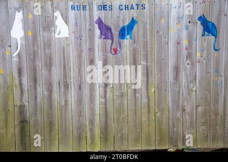 Rue des chats ou rue des chats au pochoir sur une clôture en bois à St. Pierre, France Banque D'Images