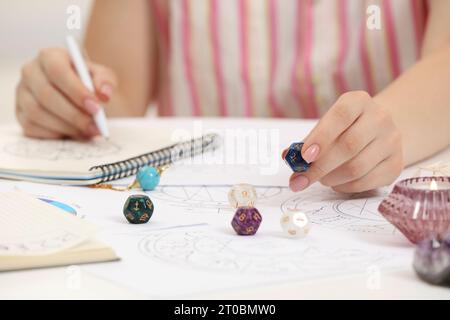 Astrologue utilisant des dés pour la prévision de destin à table, gros plan. Dire la fortune Banque D'Images