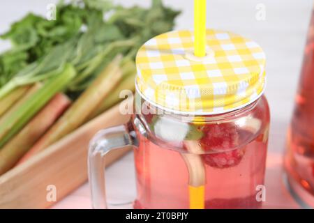 Pot Mason de savoureux cocktail rhubarbe avec framboise sur table, gros plan Banque D'Images