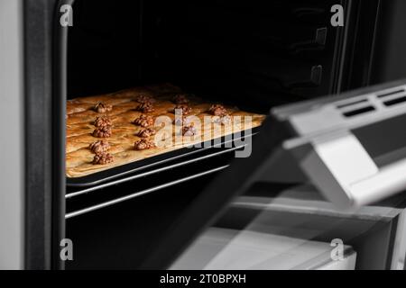 Poêle à cuire de délicieux baklava avec des noix dans le four Banque D'Images