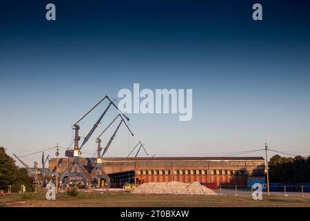 Photo de grues métalliques hautes dans un port des balkans, dans le port de belgrade, utilisées pour les conteneurs sur les navires , pour charger et décharger des marchandises. Banque D'Images