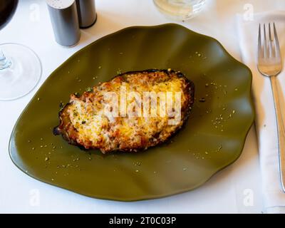 Moitié cuite au four d'aubergines gratinées au fromage Banque D'Images