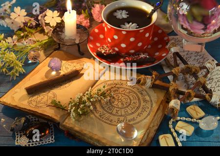 Ouvrez le journal des sorcières avec wiccan vacances chat, runes et tasse de café. Nature morte occulte, ésotérique et divinatoire. Fond mystique avec objet vintage Banque D'Images