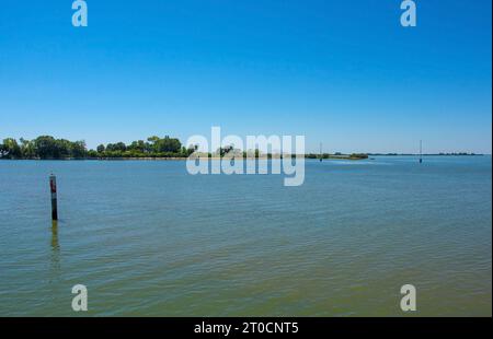 Un marqueur de canal montre le bord d'un canal navigable dans les eaux peu profondes de la section Grado de la lagune de Marano et Grado au Frioul, en Italie Banque D'Images