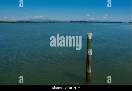 Un marqueur de canal montre le bord d'un canal navigable dans les eaux peu profondes de la section Grado de la lagune de Marano et Grado au Frioul, en Italie Banque D'Images