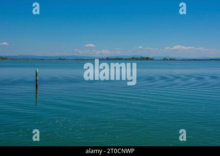 Un marqueur de canal montre le bord d'un canal navigable dans les eaux peu profondes de la section Grado de la lagune de Marano et Grado au Frioul, en Italie Banque D'Images