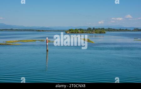 Un marqueur de canal montre le bord d'un canal navigable dans les eaux peu profondes de la section Grado de la lagune de Marano et Grado au Frioul, en Italie Banque D'Images