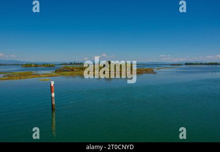 Un marqueur de canal montre le bord d'un canal navigable dans les eaux peu profondes de la section Grado de la lagune de Marano et Grado au Frioul, en Italie Banque D'Images