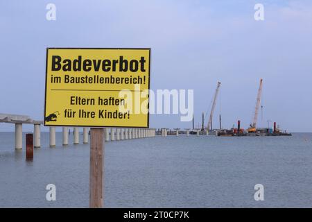 Der Schriftzug Badeverbot ist am Donnerstag 28.09.2023 in Prerow Vorpommern Rügen am örtlichen Strand auf einem Schild zu lesen. Im hintergrund ist die Baustelle für den neuen Inselhafen zu sehen. Der Hafen entsteht als Ersatzhafen für den Nothafen Darßer Ort der jetzt geschlossen wird. Guerre dieser in den zurückliegenden Jahren immer wieder versandet und musste ausgebaggert werden. Dadurch waren dans regelmäßigen Abständen hohe Kosten entstanden. Infolge hatte sich das Land MV dazu entschlossen, Am Standort der örtlichen Seebrücke einen Neubau zu errichten. Zu diesem wird künftig u.a. auch eine n Banque D'Images