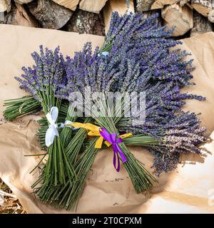 Les bouquets de lavande avec des rubans violets et jaunes reposent sur du papier Banque D'Images