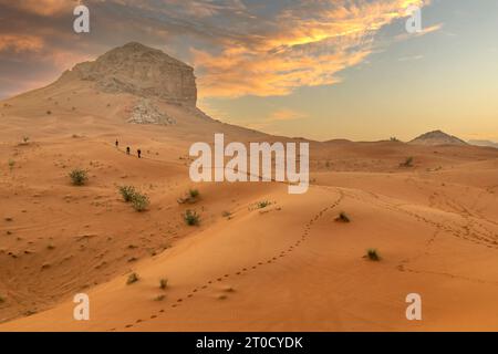 Vue imprenable sur le désert et les dunes de Dubaï. Des gens marchant tôt le matin dans le désert Banque D'Images