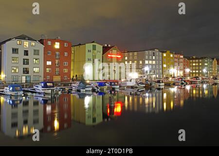 Des maisons lumineuses de différentes couleurs se reflètent dans les eaux calmes de la rivière Nidarelva, Trondheim, Troendelag, Norvège Banque D'Images