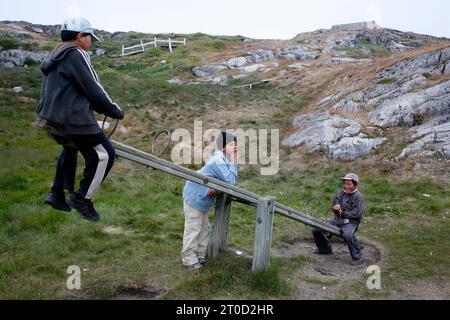 Jeunes adolescents jouant dans le petit village d'Itilleq, Groenland. Banque D'Images