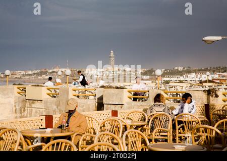 Les gens assis dans un café le long de la Corniche côté plage. Casablanca, Maroc. Banque D'Images