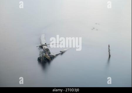 Un bateau abandonné, à moitié submergé dans un lac Banque D'Images