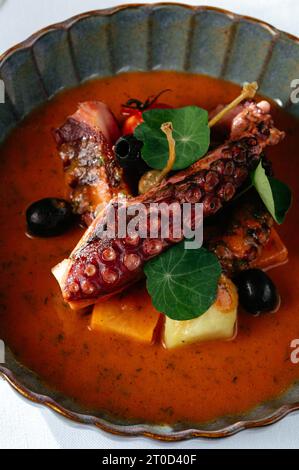poulpe grillé avec sauce tomate et légumes. un verre de whi Banque D'Images