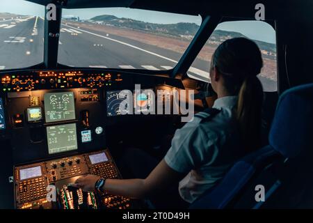 Étudiante pilote dans le cockpit d'un avion de ligne Banque D'Images