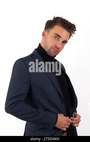 Un jeune homme beau respire le professionnalisme et le style dans sa tenue d'affaires comme il pose avec confiance Banque D'Images