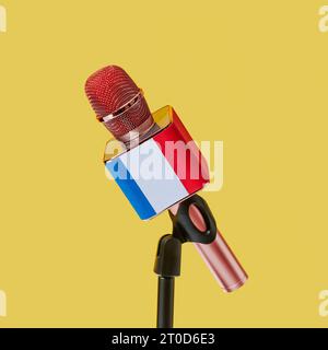 gros plan d'un microphone rose à motif du drapeau de France, sur un support noir, sur fond jaune, dans un format carré Banque D'Images