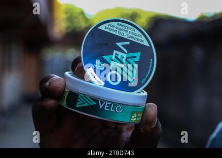 Nakuru, Kenya. 06 octobre 2023. Une main tient un récipient en plastique de la marque de nicotine Velo de British American Tobacco (BAT) à Nakuru. Le Parlement kenyan débat de l'imposition d'une interdiction de la marque Velo de sachets de nicotine fabriqués en Hongrie par British American Tobacco, avec des préoccupations découlant de la dépendance à la substance et des effets nocifs potentiels sur la santé des utilisateurs. Crédit : SOPA Images Limited/Alamy Live News Banque D'Images