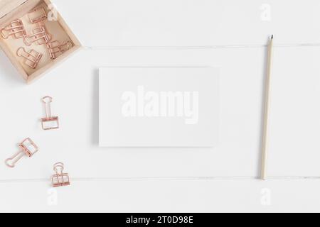Vue de dessus d'une maquette de carte blanche avec des accessoires d'espace de travail sur une table blanche. Banque D'Images