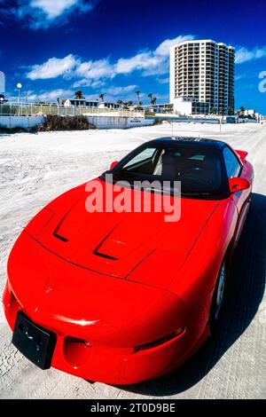 Red Pontiac Firebird Trans Am 1995 série 3 modèle garé sur le sable à Daytona Beach, Floride, États-Unis Banque D'Images