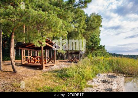 Gazebos en bois sur la rive du lac blanc dans la région de Rivne, Ukraine. Banque D'Images