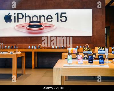 Paris, France - 22 septembre 2023 : n Apple Store vide présente un panneau d'affichage en magasin bien en vue, affichant du texte volumineux pour l'iPhone 15 ainsi qu'une image de son système à triple caméra Banque D'Images