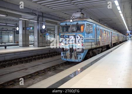 Un vieux train parsemé de graffitis traverse la gare principale souterraine de Prokop à Belgrade, en Serbie Banque D'Images