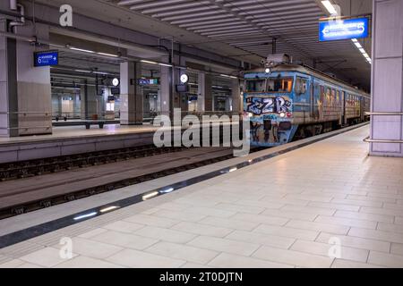 Un vieux train parsemé de graffitis traverse la gare principale souterraine de Prokop à Belgrade, en Serbie Banque D'Images