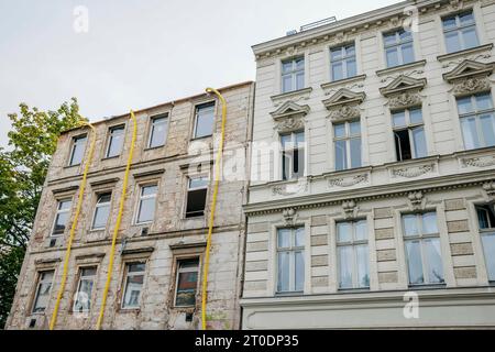 Photo symbolique sur le thème de la rénovation de bâtiments anciens. Un immeuble résidentiel à rénover à Berlin se trouve à côté d'une maison qui a déjà été rénovée. Berlin, 6 octobre 2023. Banque D'Images