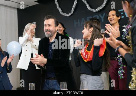 Un groupe de gens d'affaires et de collègues s'amusant ensemble lors d'une fête du nouvel an d'affaires. Une célébration en équipe d'une cible réussie. Confettis an Banque D'Images