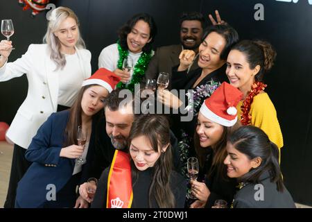 Prenons un selfie !! Un groupe de gens d'affaires divers et collègues s'amusant ensemble à une fête du nouvel an d'affaires. Une célébration de travail d'équipe d'un Banque D'Images