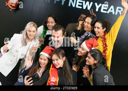 Prenons un selfie !! Un groupe de gens d'affaires divers et collègues s'amusant ensemble à une fête du nouvel an d'affaires. Une célébration de travail d'équipe d'un Banque D'Images