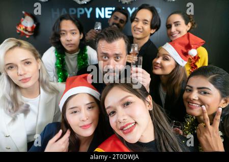 Prenons un selfie !! Un groupe de gens d'affaires divers et collègues s'amusant ensemble à une fête du nouvel an d'affaires. Une célébration de travail d'équipe d'un Banque D'Images