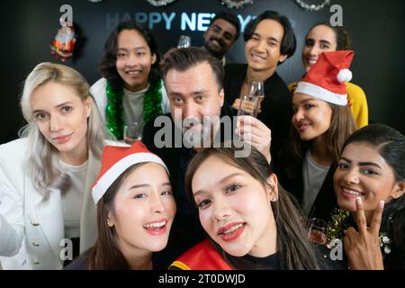Prenons un selfie !! Un groupe de gens d'affaires divers et collègues s'amusant ensemble à une fête du nouvel an d'affaires. Une célébration de travail d'équipe d'un Banque D'Images