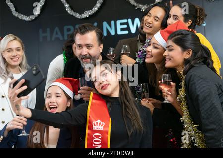Prenons un selfie !! Un groupe de gens d'affaires divers et collègues s'amusant ensemble à une fête du nouvel an d'affaires. Une célébration de travail d'équipe d'un Banque D'Images