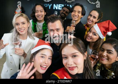 Prenons un selfie !! Un groupe de gens d'affaires divers et collègues s'amusant ensemble à une fête du nouvel an d'affaires. Une célébration de travail d'équipe d'un Banque D'Images