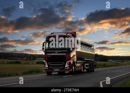 Rouge Volvo FH Truck aire Auto tire une semi-remorque de réservoir sur l'autoroute 10 en lumière du soir. Koski TL, Finlande. 21 septembre 2023. Banque D'Images