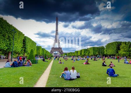 Paris 7e arrondissement. Le champ de Mars avec les touristes au pied de la tour Eiffel. Paris Ile de France. France Banque D'Images