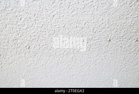 Plafond avec gouttes d'eau de fuite d'eau active. Plafond de pop-corn blanc qui s'égoutte d'une fine et longue fissure. Plafond d'inondation en cas d'éclatement de tuyau, incendie sp Banque D'Images