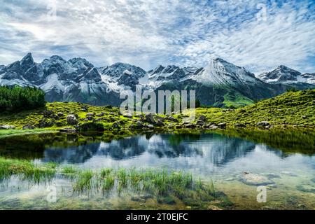 Petit lac devant des montagnes enneigées sur une journée ensoleillée d'été près d'Oberstdorf. Guggersee, Alpes de Allgäu, Bavière, Allemagne, Europe Banque D'Images