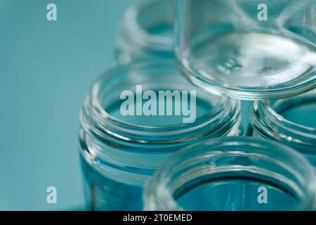 Bocaux en verre vides avec bords filetés et fond bleu Banque D'Images