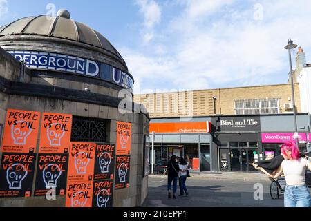 Londres, Royaume-Uni. 6 octobre 2023. Des affiches orange vif et noires portant le slogan « People vs Oil » ont été plâtrées à l'extérieur de la station de métro Clapham Common par le groupe de campagne environnementale Just Stop Oil. Le groupe prévoit une série de manifestations pacifiques à partir du 29 octobre. Crédit : Anna Watson/Alamy Live News Banque D'Images