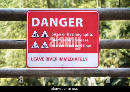 Signe de danger au sujet de la montée rapide de l'eau sur le sentier de randonnée en dessous d'un barrage. Signalisation avec consignes de sécurité en cas de sirènes auditives à la rivière. Cleveland da Banque D'Images