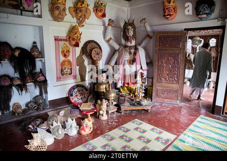 Salle pleine de masques traditionnels fabriqués par le fabricant de masques de renommée mondiale Hem Chandra Goswami, qui quitte la salle, sur l'île Majuli à Assam, en Inde Banque D'Images