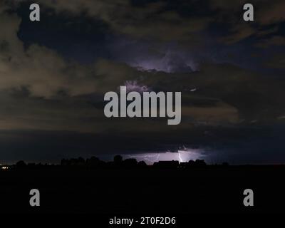 La foudre se dirige vers la Terre la nuit à partir d'un nuage d'orage lointain Banque D'Images