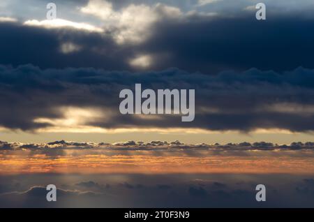 Lever du soleil avec paysage nuageux coloré spectaculaire. Beau soleil derrière les nuages jetant des formes et le contour de dentelle dans les nuages. Réglage de l'arrière-plan. Banque D'Images