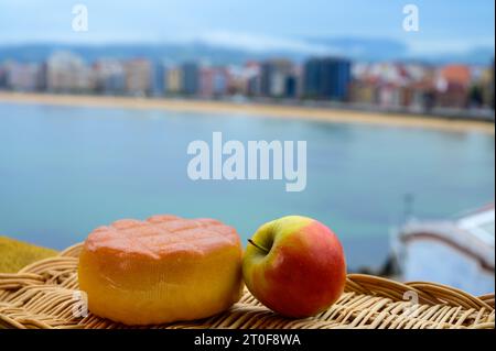 Fromage de vache fumé espagnol de Pria, Asturies, servi en plein air avec vue sur la plage de San Lorenzo et la promenade de Gijon Banque D'Images